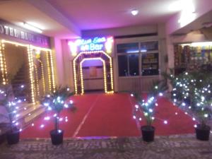 哥印拜陀Hotel Blue Star的一间铺有红地毯并配有 ⁇ 虹灯标志的房间