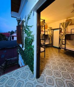 琅勃拉邦Sabai Sabai Backpackers Hostel的客房设有带绿色植物的阳台。