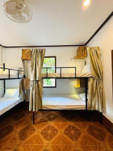 琅勃拉邦Sabai Sabai Backpackers Hostel的带窗户的客房内的两张双层床