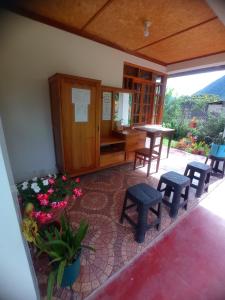 奥克萨潘帕Hospedaje Pinky Lodge的一间设有椅子和桌子的房间,还有一些鲜花
