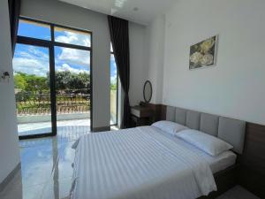波来古市Nine Hotel Gia Lai的一间卧室设有一张床和一个大窗户