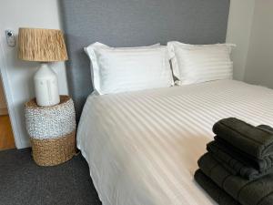 堪培拉NEW BOUTIQUE 1bd Apt的卧室配有白色床、灯具和毛巾
