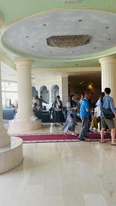 苏尔苏尔海滩假日度假酒店的一群人站在大厅里,有柱子