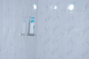 Tulivu homes的浴室设有白色大理石瓷砖和淋浴。