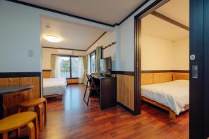 神户晨曦山林小屋酒店的客房设有两张床、一张桌子和一面镜子。