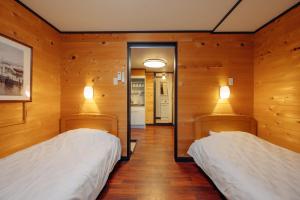 神户晨曦山林小屋酒店的木墙客房的两张床