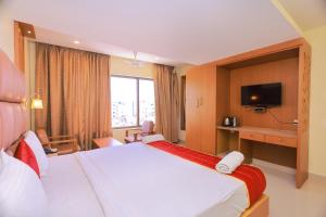 根尼亚古马里Hotel Sangam的酒店客房设有一张大床和一台电视。