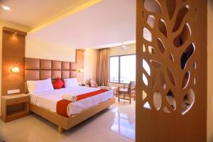 根尼亚古马里Hotel Sangam的配有一张床和一张书桌的酒店客房