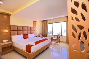 根尼亚古马里Hotel Sangam的酒店客房设有一张床和一个大窗户