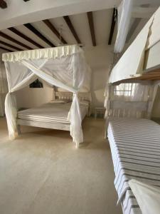 马林迪Coral Village的卧室配有2张双层床和白色床单