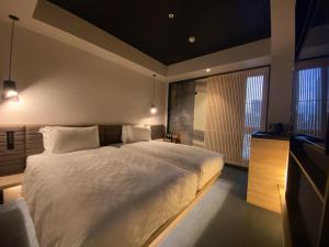 大阪Hotel Resol Trinity Osaka的一间卧室配有一张大床和电视