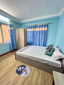 加德满都Sagarmatha View Homes的一间卧室配有一张蓝色墙壁和木地板。