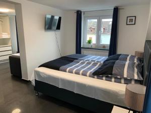 罗拉赫Günstiges Privatzimmer的一间卧室设有一张床、一个窗口和一台电视