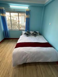 加德满都Sagarmatha View Homes的一间卧室配有一张带蓝色墙壁的大床