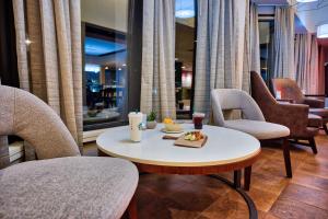 汉普顿汉普顿万怡酒店的一间设有椅子和一张桌子的房间,提供食品托盘