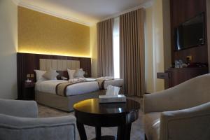 麦地那Roaa Al Andalus Hotel فندق رؤى الاندلس的酒店客房带一张床、一张桌子和椅子
