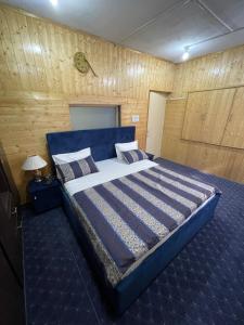 斯利那加Khwaab Gah by The Khayabaan-HomeStay 3 BHK, 2 BHK & 1 BHK Apartments in City Centre的一间卧室配有一张大床和蓝色床头板