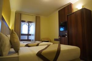 麦地那Roaa Al Andalus Hotel فندق رؤى الاندلس的酒店客房设有两张床和电视。