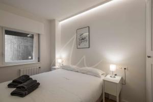 上阿兰Saboredo by SeaMount Rentals的一间卧室配有一张白色床、两个床头柜和两盏灯。