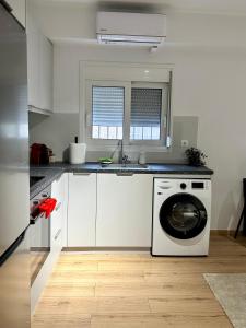 帕特雷City Centre Apartment的白色的厨房配有洗衣机