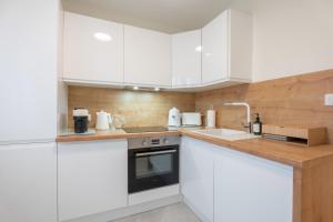 米卢斯LE N'ESPRESSO的厨房配有白色橱柜和水槽
