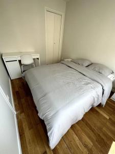 La MulatièreAppartement 6 places, 3 chambres的卧室设有一张白色大床和木地板