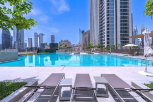 迪拜Stunning Views, Luxury Residence By Chi Living的一个带躺椅的大型游泳池,享有城市天际线