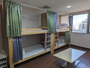 台北黑熊好眠站旅馆 (台北桥店)的客房设有带窗户的双层床。