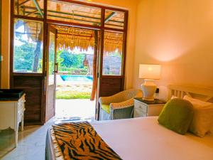 锡吉里亚Sigiriya Elegant Resort的一间卧室设有一张床和一个滑动玻璃门