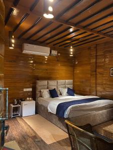 北拉欣布尔Lemonwood cottage的一间卧室配有一张带木墙的大床