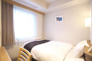 横手市Yokote Plaza Hotel的酒店客房设有床和窗户。