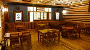 山之内町Shibu Onsen Koishiya Ryokan的餐厅设有木桌、椅子和窗户。