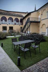克雷马CallMe Crema - Struttura in centro storico的大楼前的一张野餐桌和两把椅子