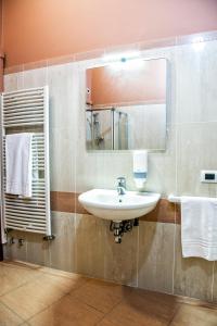 克雷马CallMe Crema - Struttura in centro storico的浴室配有盥洗盆、镜子和毛巾