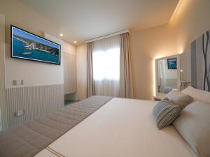 梵蒂冈角伊登村公寓式酒店的卧室配有一张大床,墙上配有电视