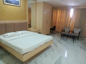 拉特纳吉里Vits Select Grand Inn, Ratnagiri的一间带大床的卧室和一间客厅