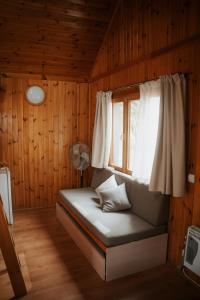 阿尔克萨尔Camping Alquézar的客房设有带窗户和风扇的床。