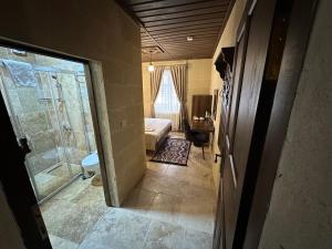 格雷梅Virtus Cappadocia Hotel Göreme的一间带淋浴的浴室和一间带一张床的卧室