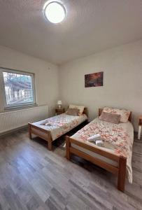 萨拉热窝Apartment Rea Ilidža 2的一间卧室设有两张床和窗户。