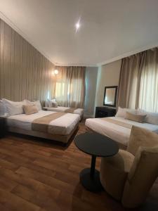 卡萨布兰卡Cadé Hotel的酒店客房,配有两张床和椅子