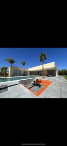 马拉喀什Villa ISSA的一座带游泳池和棕榈树的建筑