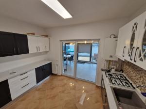 CornetuVila 12的厨房配有白色橱柜和炉灶烤箱。