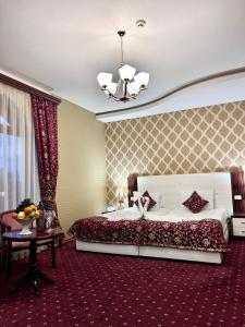 埃里温亚美尼亚皇宫酒店的一间大卧室,配有一张大床和一张桌子