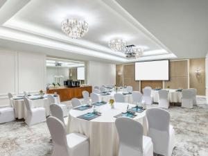 迪拜索菲特迪拜朱美拉海滩酒店的一间会议室,配有白色的桌子和白色的椅子
