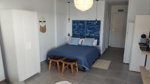 卡拉德米哈斯Loft La Cala de Mijas beach estudio mirando al mar的一间卧室配有蓝色的床和两把椅子