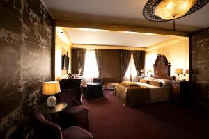 威尼斯Hotel Metropole Venezia的酒店客房,设有两张床和一张沙发