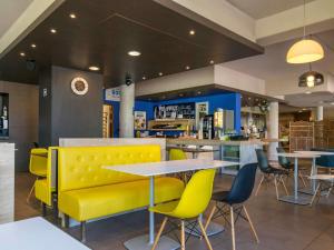 阿尔尚阿尔尚日内瓦堡宜必思快捷酒店的餐厅设有黄色长凳和桌椅