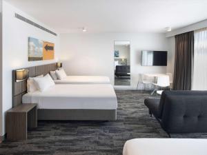 布莱克敦Mercure Sydney Blacktown的酒店客房带两张床和一个客厅