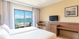 圣保罗湾城DoubleTree by Hilton Malta的酒店客房设有一张床、一台电视和一扇窗户。