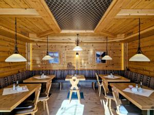 贝旺阿尔姆劳什贝格酒店的餐厅设有木桌、椅子和吊灯